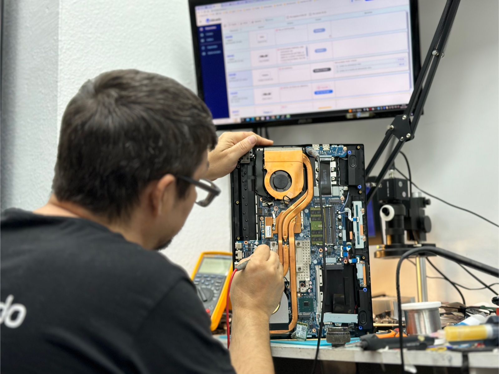 Técnico de Dalvado diagnosticando la placa de un portátil en el taller